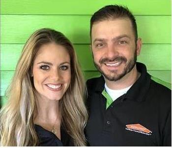 Matt and Lindy Marchese, man and woman posing in front of green wall